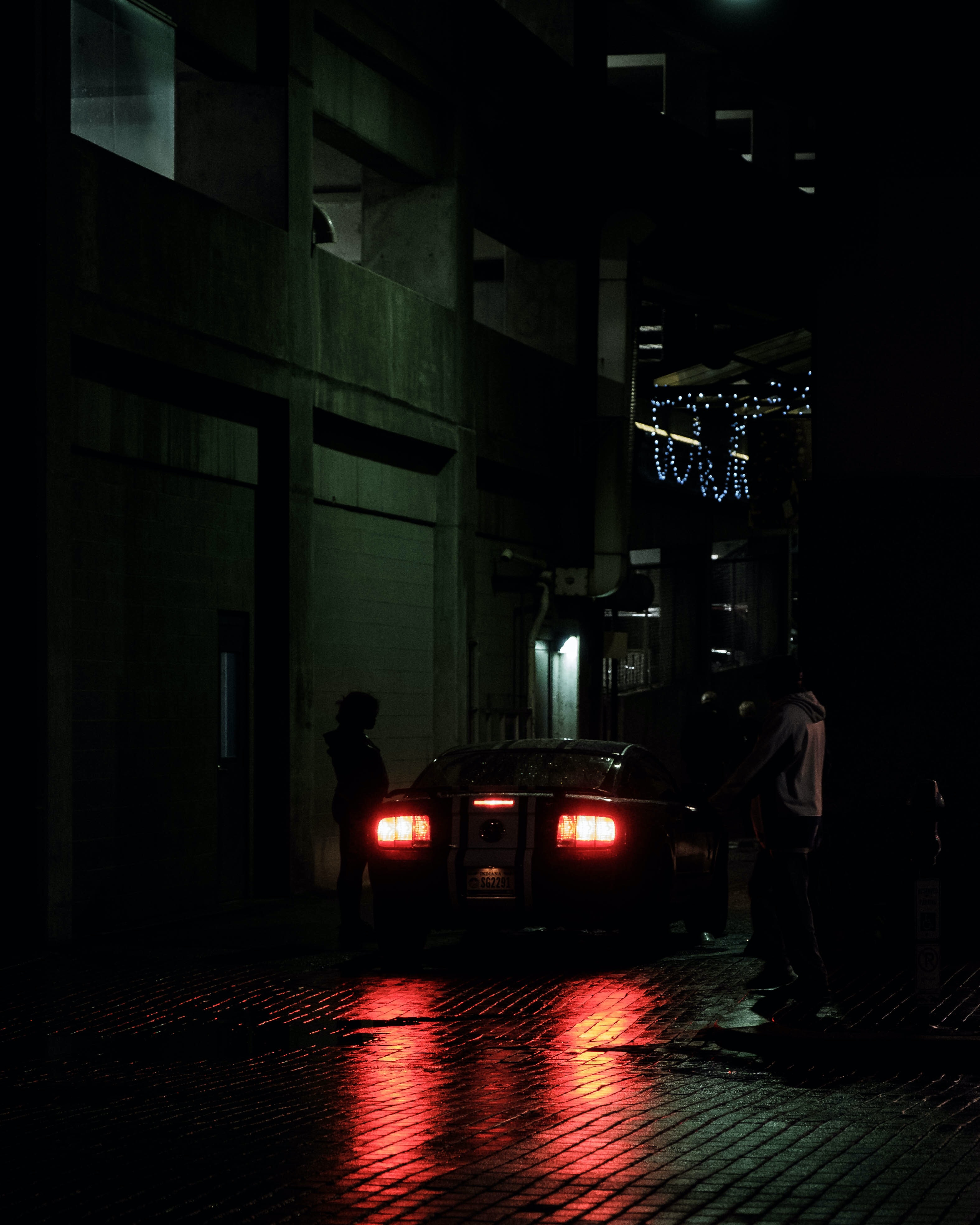 Picture of two people standing beside a car at night