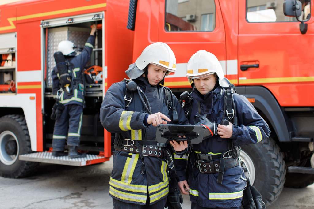 Firefighters looking at a rugged tablet.