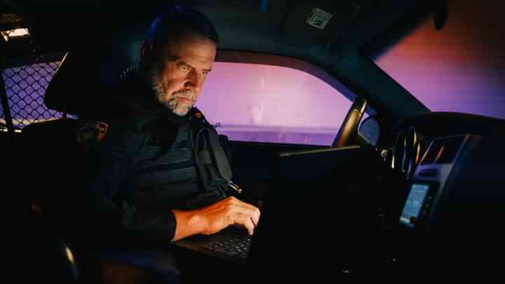 Police Officer working in their car in the dark